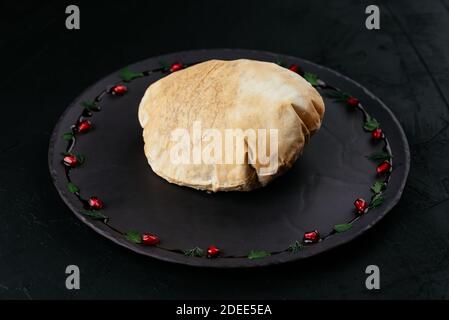 Insalata di verdure georgiane in pane di tortilla su sfondo nero Foto Stock