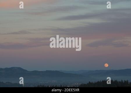 Una luna piena che sorge su Eugene, Oregon, USA. Foto Stock