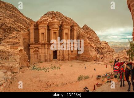 Petra, Giordania - Gennaio 13 2020: I turisti sembrano minuscoli di fronte al vasto Monastero (El Deir), il più grande monumento sul sito archeologico, costruito b Foto Stock