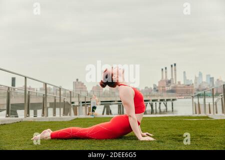 Giovane atleta che si allunga sul lungomare di Brooklyn. Foto Stock