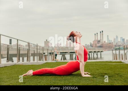 Giovane atleta che si allunga sul lungomare di Brooklyn. Foto Stock