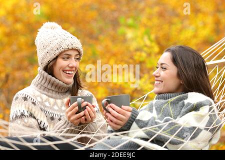 Due amici felici che parlano in vacanza autunnale in montagna Foto Stock