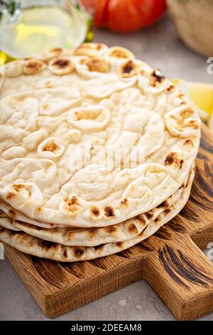 Una pila di pane pita su un tagliere Foto Stock