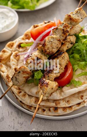 Souvlaki di pollo con verdure fresche su un pane piatto Foto Stock