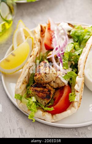 Souvlaki di pollo con verdure fresche su un pane piatto Foto Stock