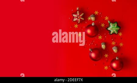 Ampia composizione natalizia. Decorazioni di Natale in rosso, oro e verde su sfondo rosso. Foto Stock