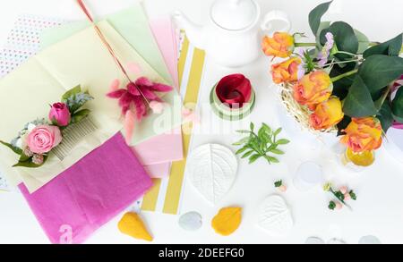 Fare fiori artificiali a mano come un hobby creativo. Scrivania di design fiorista. Un bouquet di rose gialle fatte a mano di foamiran, un tornante artificiale Foto Stock