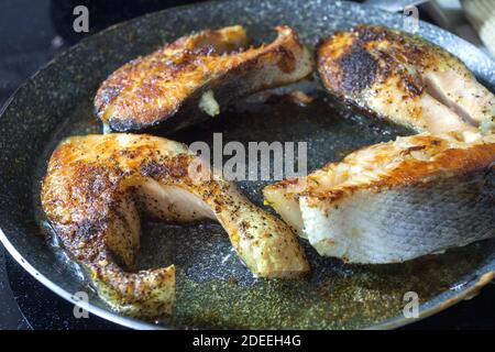 Bistecche di salmone fritte in padella con crosta dorata. Foto Stock