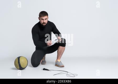 personal fitness trainer tenere appunti con piano di allenamento su bianco sfondo Foto Stock