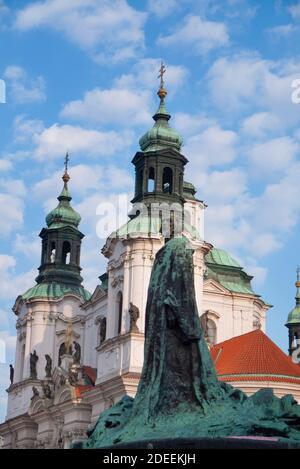 Jan Hus statua con la chiesa di San Nicola dietro nella città vecchia, Praga, capitale della Repubblica Ceca Foto Stock