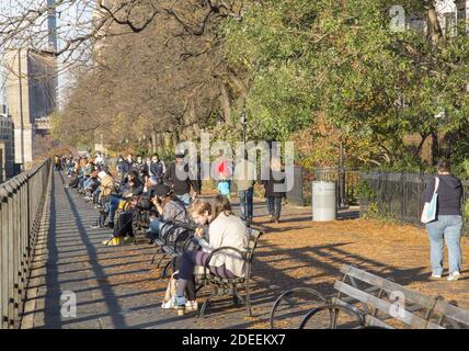 Le persone si rilassano in una soleggiata giornata autunnale lungo la Promenade nel quartiere Brooklyn Heights di Brooklyn, New York. Foto Stock