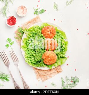 Polpette di pesce o cotolette di merluzzo con verdure verdi, vista dall'alto Foto Stock