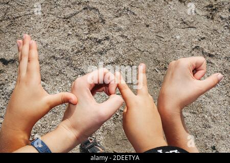 Parola Amore fatto di mani di bambini, su sfondo di sabbia Foto Stock