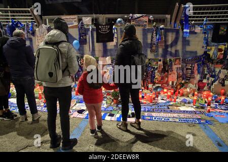 I genitori con la figlia guardano gli oggetti lasciati da Fan di Napoli in memoria di Diego Armando Maradona in Davanti alle porte dello stadio San Paolo Foto Stock