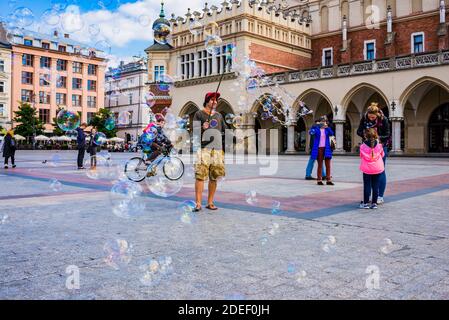 Bambini che giocano con le bolle di sapone nella piazza principale del mercato, Cracovia, Contea di Kraków, Lesser Poland Voivodato, Polonia, Europa Foto Stock