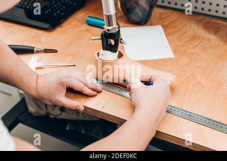 tecnico di protesi che controlla gli stampi delle protesi in un'officina Foto Stock