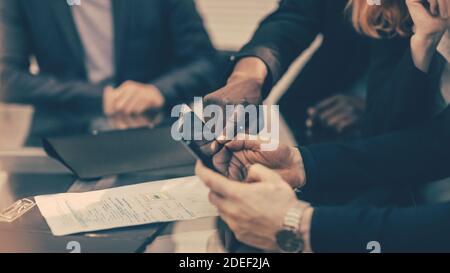 primo piano. i colleghi di lavoro visualizzano i messaggi su uno smartphone Foto Stock