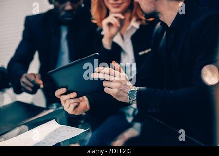 primo piano. team aziendale che guarda lo schermo di un tablet digitale. Foto Stock