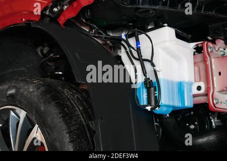 un serbatoio con liquido lavavetri e un motore per l'alimentazione liquido nella carrozzeria Foto Stock