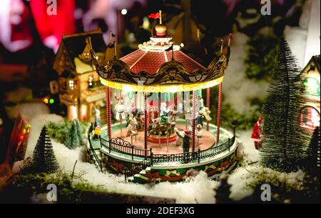 Carosello in europeo Natale Fiera giocattolo in miniatura. Scena della vigilia di Natale invernale con le tradizionali case in miniatura del villaggio. Città notte giocattolo d'epoca con Foto Stock