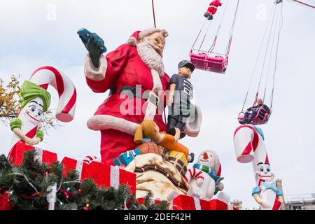 Statuina Santa Klaus in plastica. Mercatino di Natale di Parigi (giardini delle Tuileries), Francia. Bellissimo angolo basso girato lateralmente alla fiera. Foto Stock