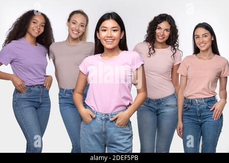 Asian Lady in piedi con un gruppo di donne diverse in studio Foto Stock