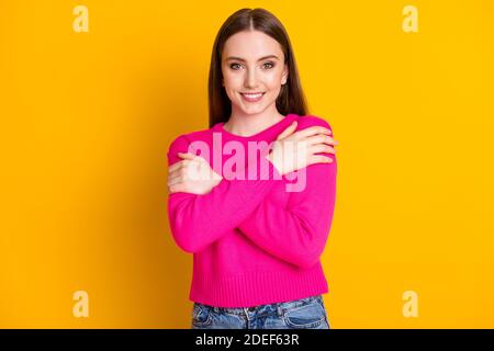 Foto di affascinante giovane signora coccolare lei stessa guardare macchina fotografica noothy smile indossare pullover rosa isolato di colore giallo sfondo Foto Stock