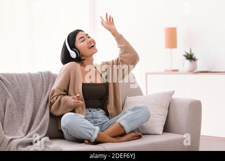 Donna asiatica che ascolta musica in cuffia e balla Foto Stock