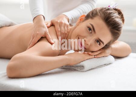 Giovane donna che si sta facendo una sessione di massaggio presso una lussuosa spa Foto Stock