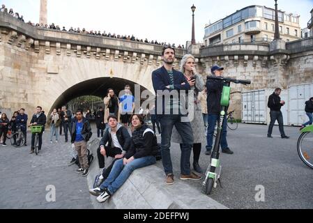 Le persone reagiscono mentre guardano le fiamme che ingolfano il tetto della Cattedrale di Notre-Dame de Paris, nella capitale francese Parigi, il 15 aprile 2019. Un enorme incendio scoppiò nella famosa Cattedrale di Notre-Dame nel centro di Parigi il 15 aprile 2019, causando il crollo di una guglia e minacciando di distruggere l'intero capolavoro e le sue preziose opere d'arte. L'incendio, che iniziò la prima sera, inviò fiamme e enormi nuvole di fumo grigio che si inondisinsero nel cielo di Parigi, mentre parigini e turisti si guardavano con orrore. Foto di Alain Apaydin/ABACAPRESS.COM Foto Stock