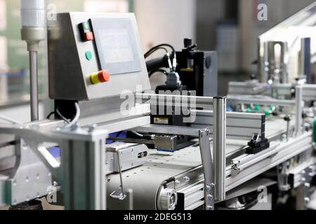 Sistema di trasporto a nastro per imballaggio automatico in un impianto farmaceutico. Messa a fuoco selettiva. Foto Stock