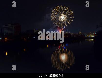 Festa di Capodanno colorati fuochi d'artificio scintillanti nel cielo di mezzanotte sulla città di Arad e Mures River, Romania Foto Stock