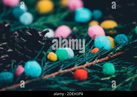 Vista closeup di alberi sempreverdi rami misti e pineconi con piccoli pomposi colorati, leggermente alternativo impostazione approccio di natale, morbido variato p Foto Stock