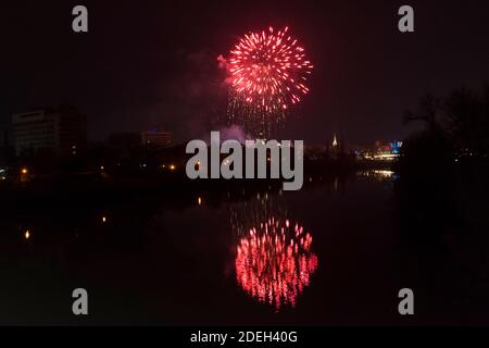 Festa di Capodanno colorati fuochi d'artificio scintillanti nel cielo di mezzanotte sulla città di Arad e Mures River, Romania Foto Stock