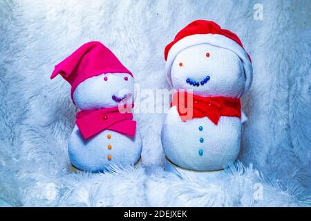 Bambole Snowman realizzate con calzini per festeggiare il Natale. Attività divertenti con i bambini a casa. Riciclare i vecchi calzini. Foto Stock