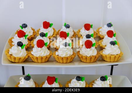 Mini dessert con frutta fresca su tavola a torta. Foto Stock