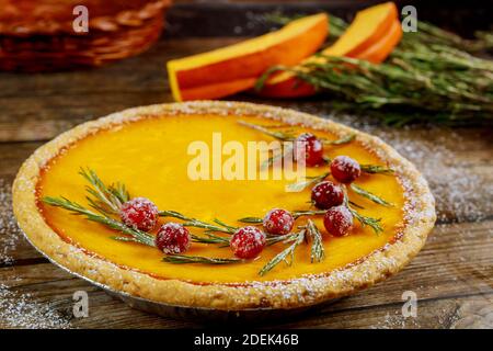 Torta di zucca con mirtillo rosso su sfondo di legno. Spazio di copia. Foto Stock