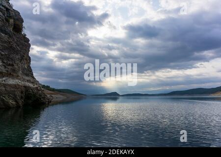 Un giro sul lago in una giornata nuvolosa. I raggi del sole filtrano attraverso le nuvole. Foto Stock