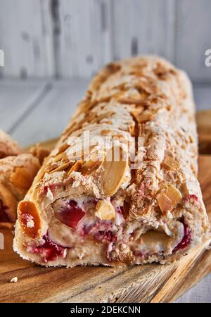 Torta Merengue con pistacchi e marmellata su una tavola di legno Foto Stock