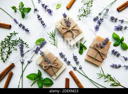 Sapone naturale con rosmarino, timo, lavanda, menta su sfondo bianco di marmo Foto Stock