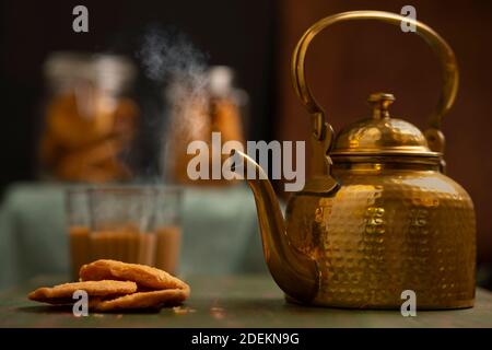 bollitore di ottone tenuto accanto a matthis con bicchieri da tè e. spuntini tenuti sullo sfondo in una sala da tè Foto Stock