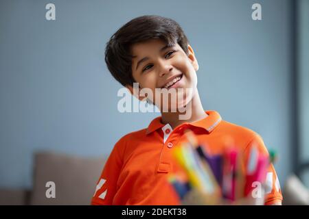 Ragazzo che guarda lateralmente con un sorriso sul viso Foto Stock