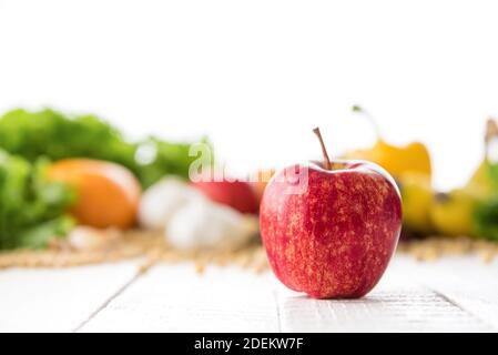 Fresco sano mela di gala su tavola di legno bianco con sfocatura frutta e verdura colorate sullo sfondo - cibo e nutrizione concetto Foto Stock