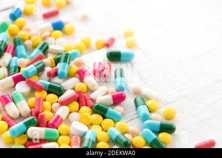 Mix di farmaci colorati e la medicina in pillola e capsula forma su tavola bianca Foto Stock