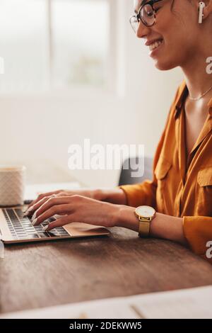 Donna che scrive un blog sul laptop. Blogger femminile che lavora su un computer portatile a casa. Foto Stock