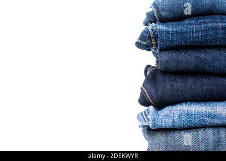 Diversi colori di jeans blu piegati in pila isolato su sfondo bianco con spazio per la copia Foto Stock