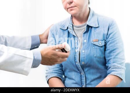 Medico che introduce e spiega il farmaco alla paziente anziana dopo aver consultato in ospedale Foto Stock