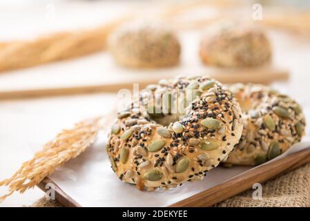Una ciambelle di ciambelle multigrain al forno sano serviti su un piatto di legno in una panetteria Foto Stock