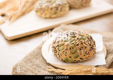 Un pane di pane multigrein al forno sano servito su un piatto di legno in una panetteria Foto Stock