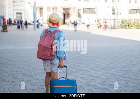 Donna turistica con zaino e valigie portagomma in attesa di volo Foto Stock